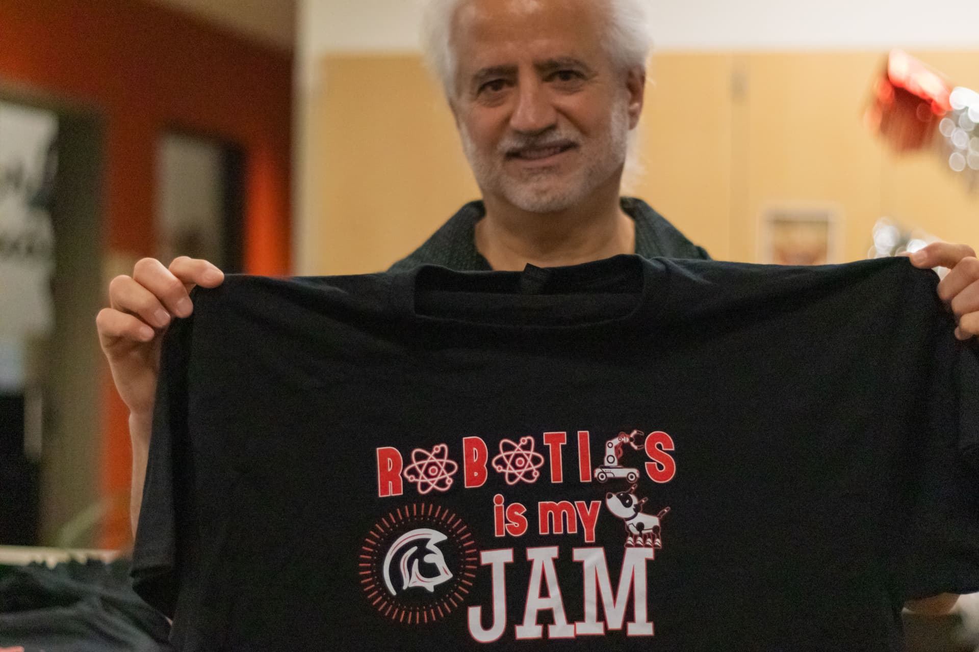 Supporter holding a "Robotics is my JAM" shirt